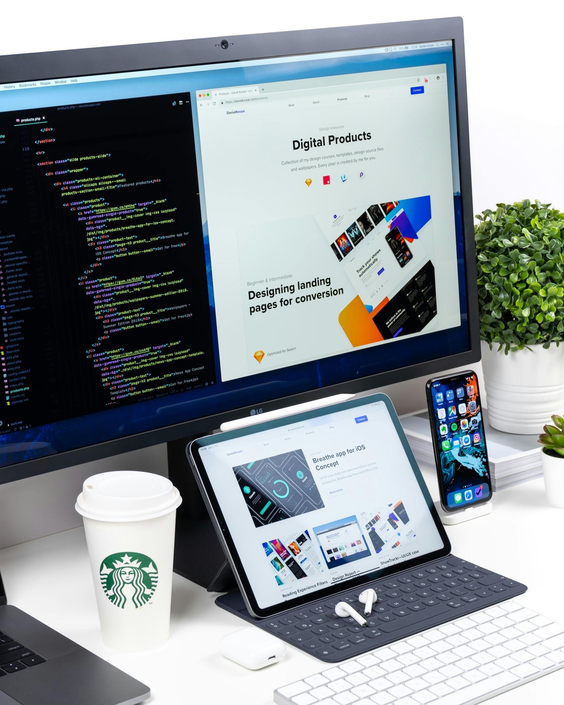 Code on computer monitor.Tablet, smartphone with headphones, keyboard and cup of coffee